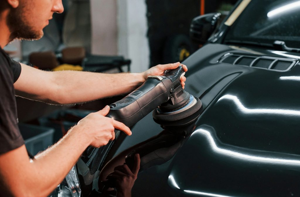 mechanic polishing a car