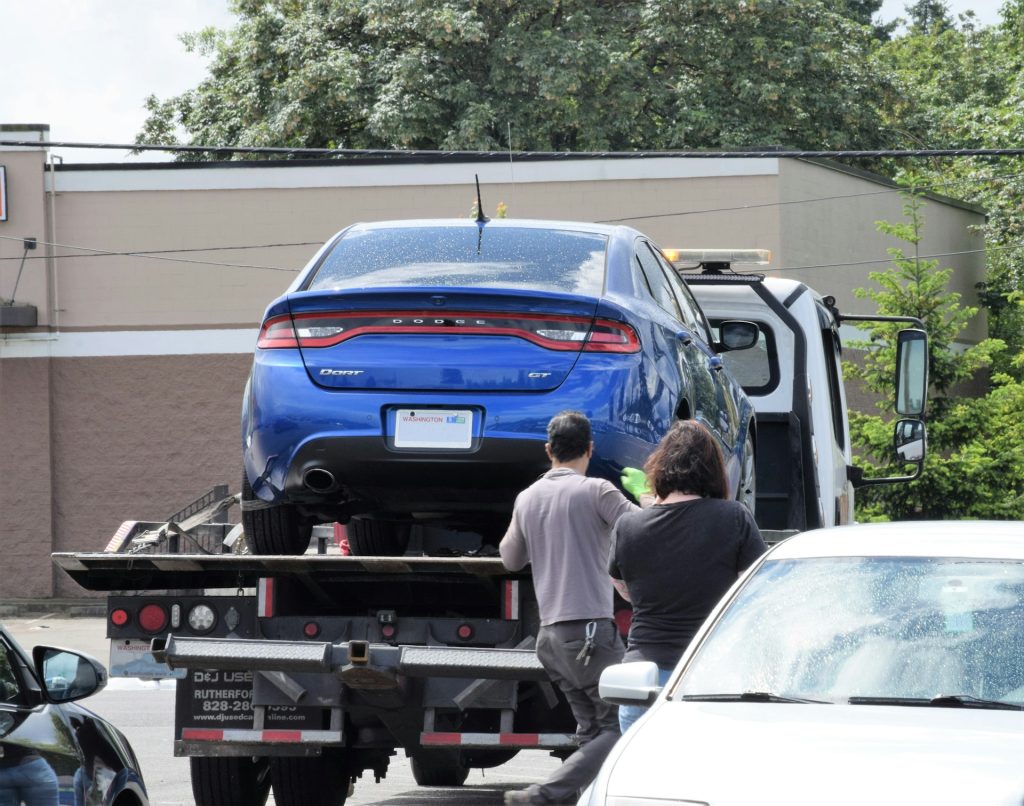a car is loaded into a towing truck