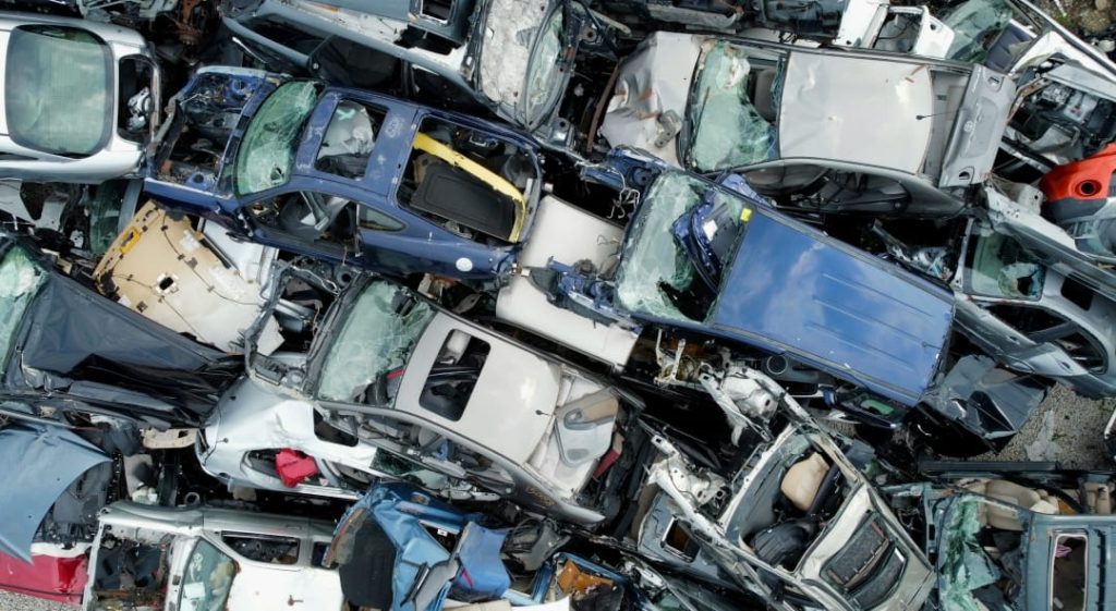 example of cars beyond repair after being totaled, stacked in a salvage yard for recycling