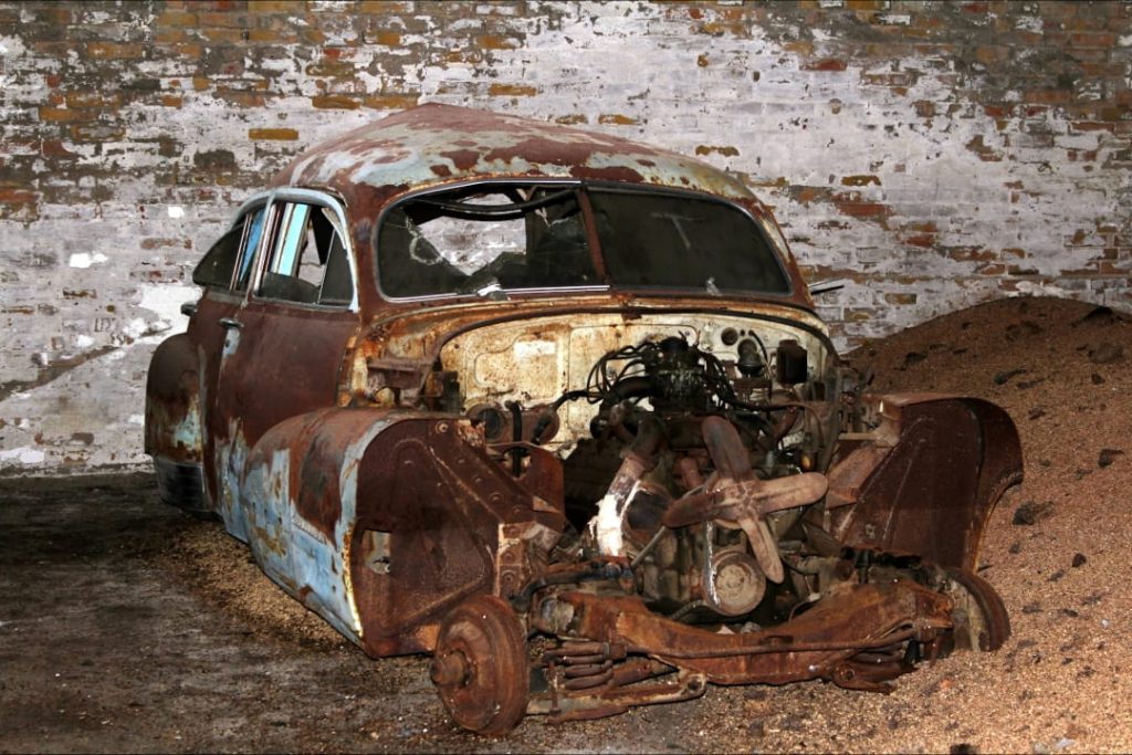 heavily rusted abandoned car with exposed engine not suitable for fixing