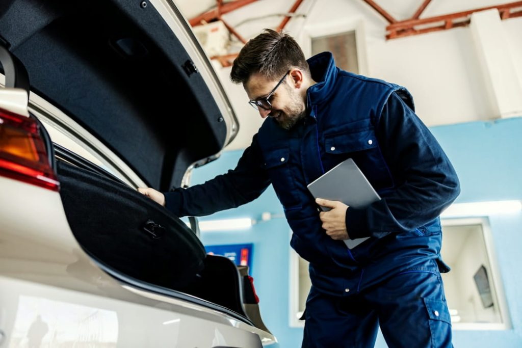 vehicle inspector checking a car’s trunk during a pre-approval inspection