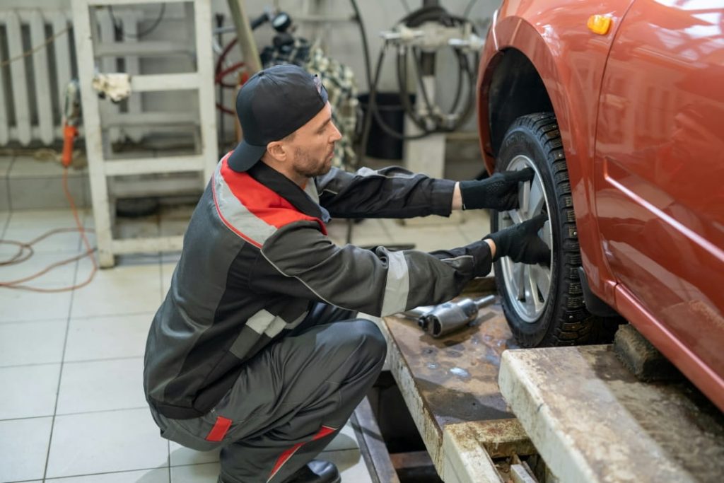 mechanic adjusting a car wheel in an auto repair shop