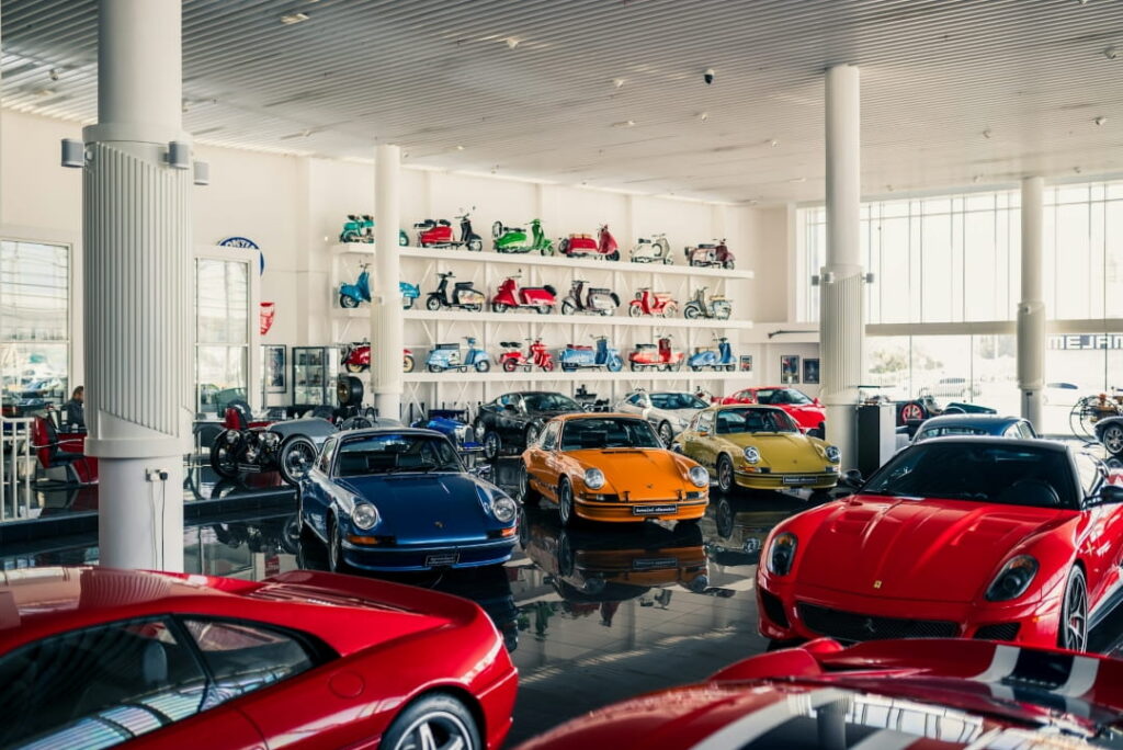 luxury and classic sports cars displayed inside a high-end indoor car showroom